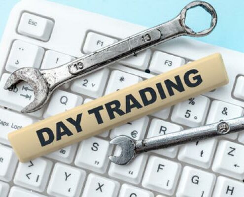 Two wrenches sit on a keyboard with a strip of wood that says "Day Trading On It"